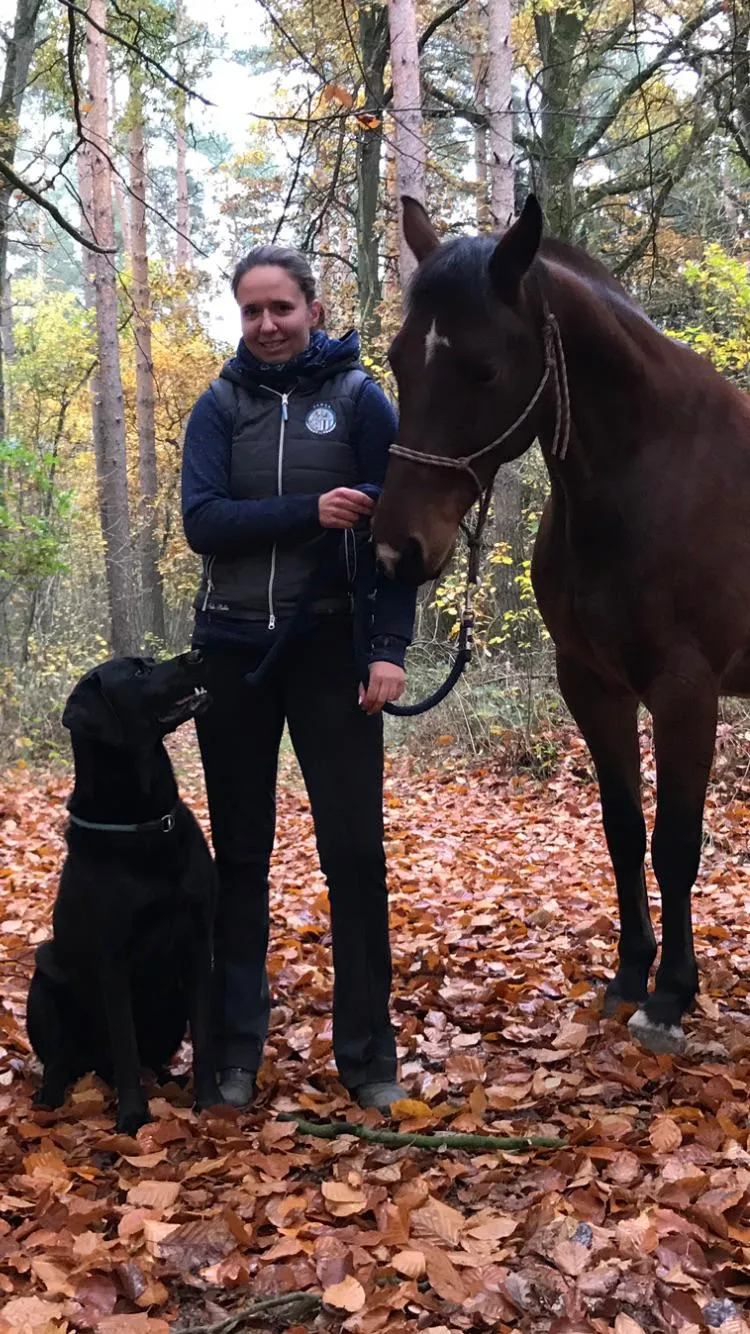 Sarah mit ihrem Pferd und Hund im Herbstwald